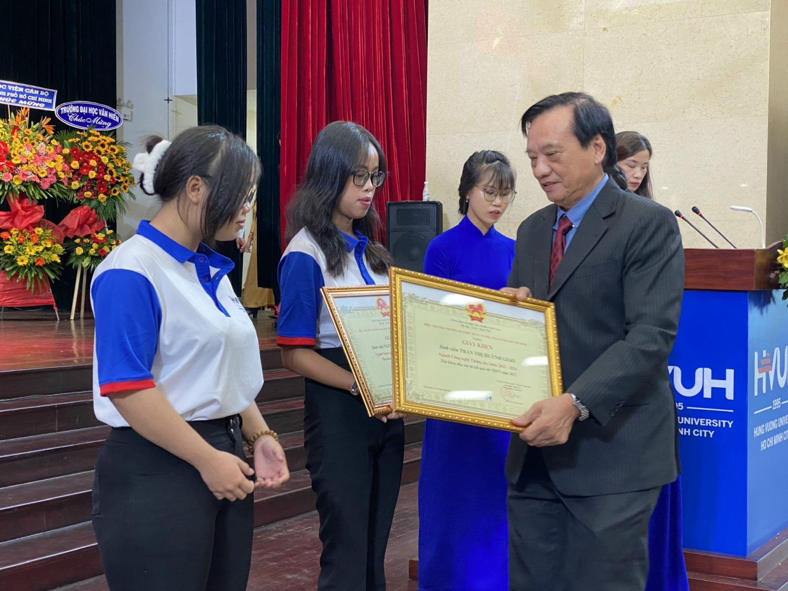 Đại diện Trường ĐH Hùng Vương TP HCM trao giấy khen cho thủ khoa kỳ tuyển sinh năm 2022