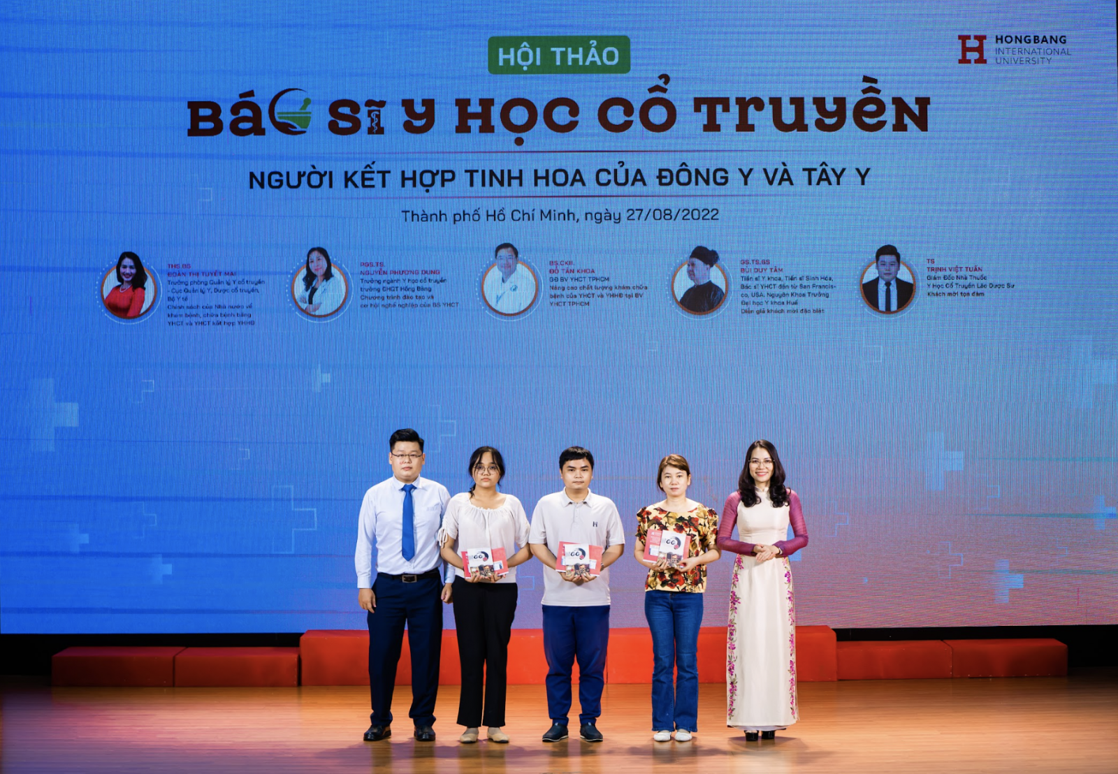 TS. Trịnh Việt Tuấn (bìa trái) cùng ThS.Trần Thúy Trâm Quyên (bìa phải) trao quà tặng cho đại diện các bạn thí sinh đăng ký nguyện vọng ngành YHCT tại HIU