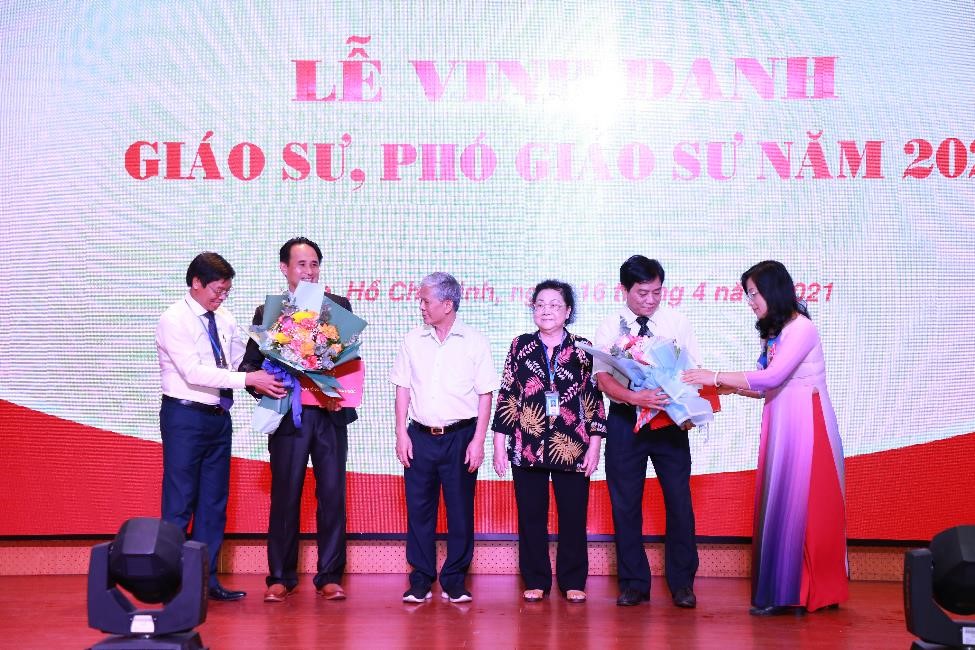 Lãnh đạo Nhà trường trao Giấy chứng nhận và hoa chúc mừng cho tân PGS Võ Tuyển và tân PGS Lê Thể Truyền