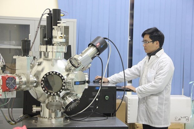 Cán bộ Khoa Vật lý làm việc trên máy tạo màng mỏng bằng chùm xung điện tử. (Ảnh: PV/Vietnam+)